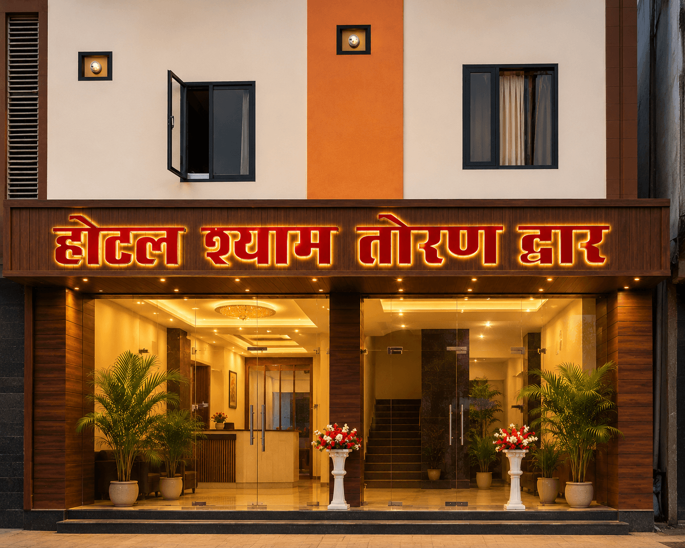 Hotel Shyam Toran Dwar illuminated facade at dusk with glowing Hindi signage